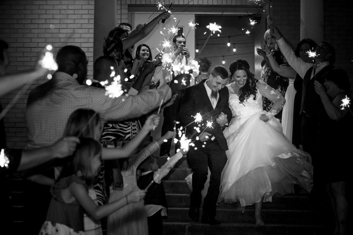 Bride and groom walking down steps sparkler exit
