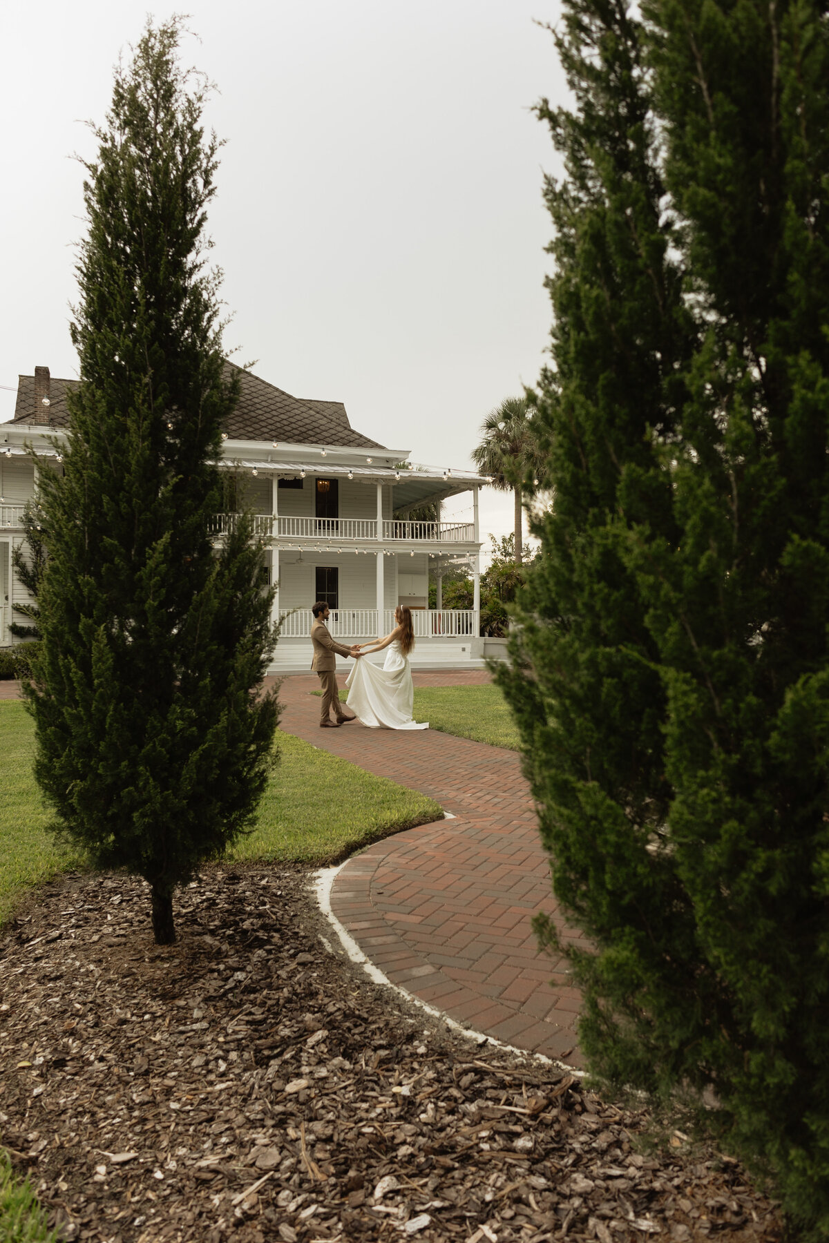 Elegant outdoor wedding surrounded by tropical greenery and historic charm at The Palm Mansion