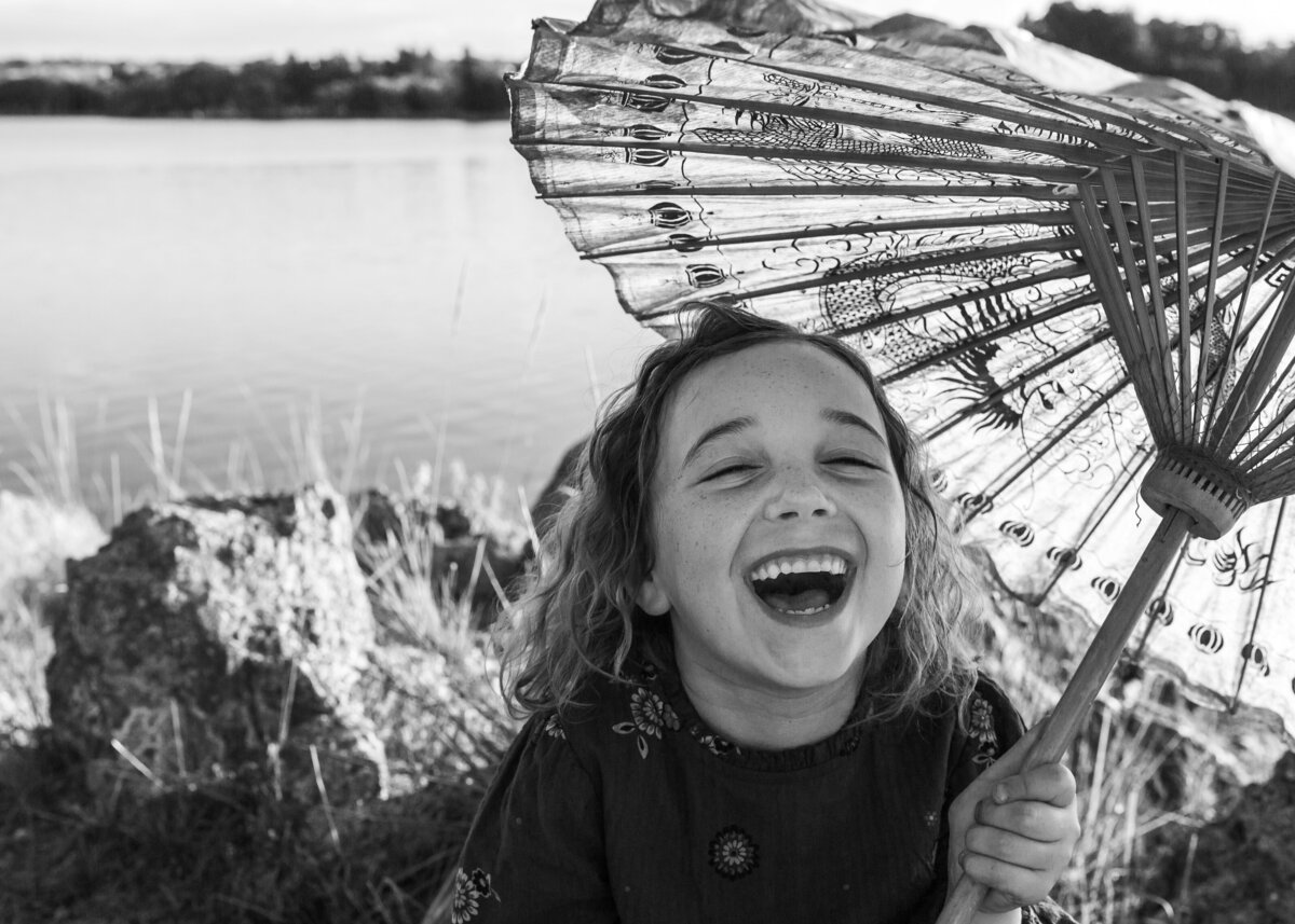 Young girl laughing holding Chinese umbrella