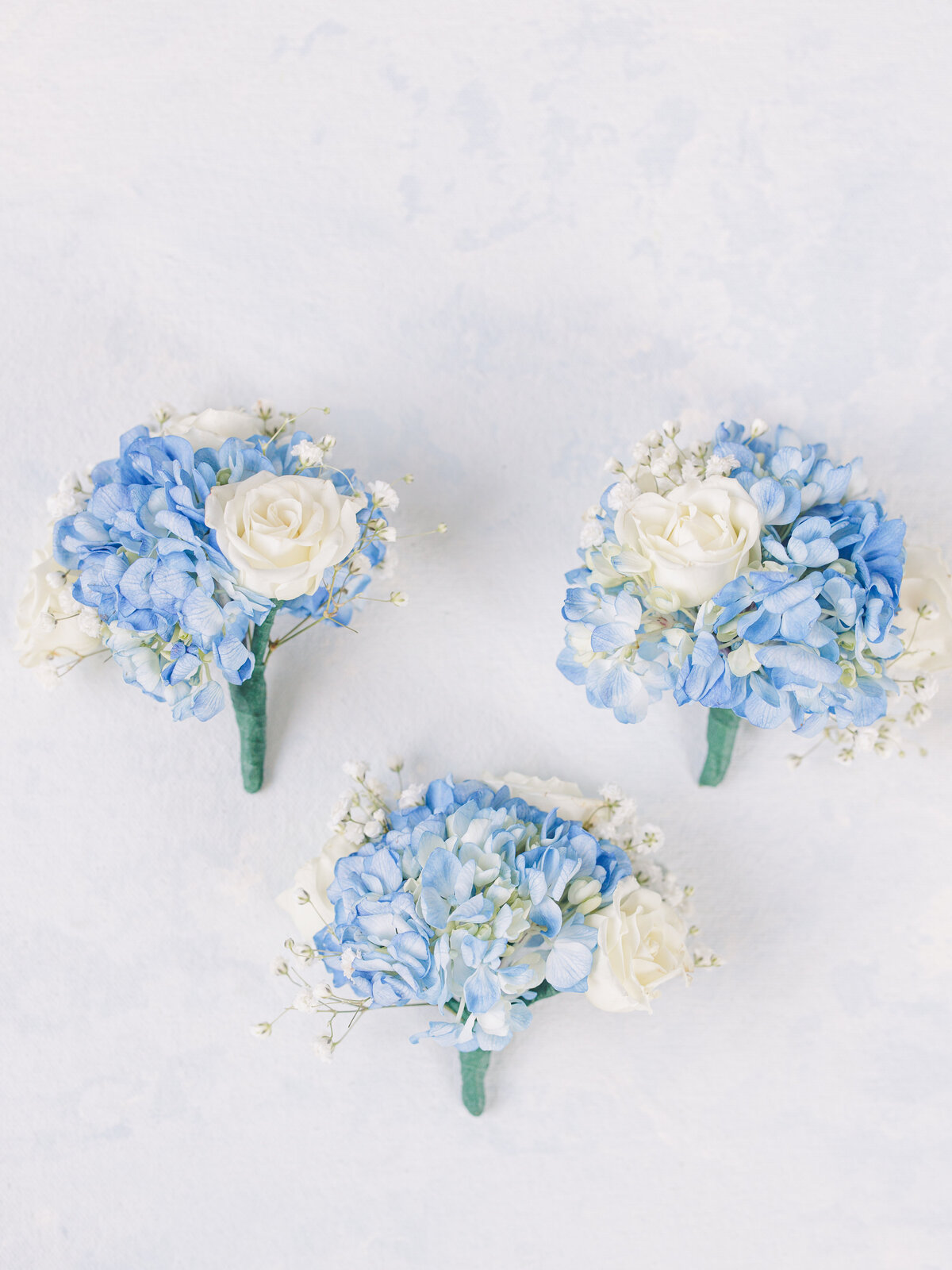 Three blue and white boutonnieres representing Cape Cod wedding photos