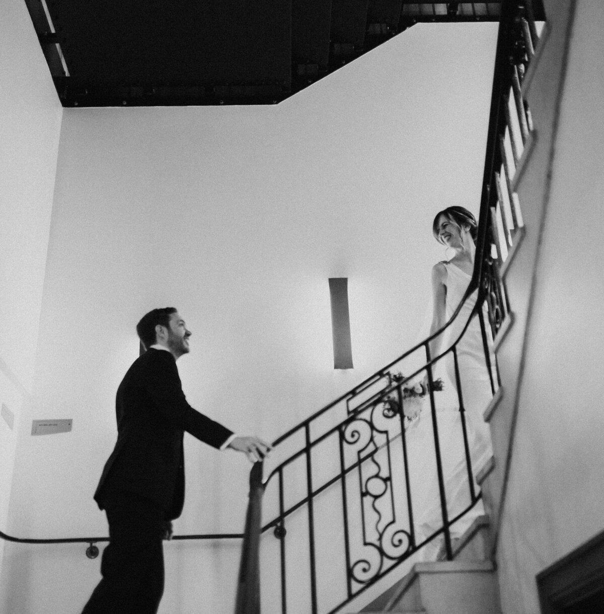 bride and groom walking up spiral staircase
