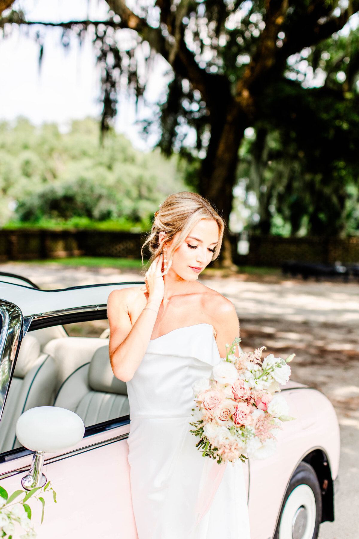 fine art wedding portrait of bride holding bouquet next to car