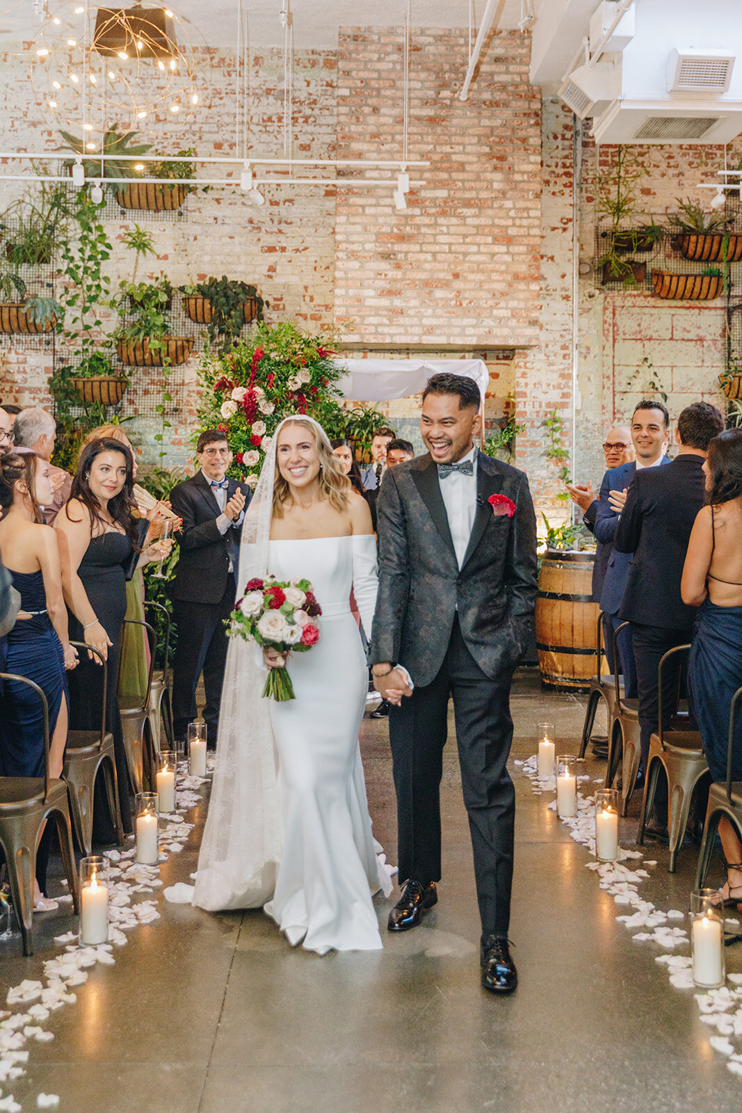 happy bride and groom walking down the aisle at brooklyn winery, with florals from Lucy's Flowers NYC