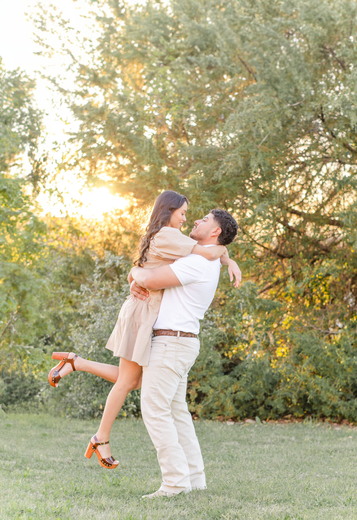 man lifts fiance into the air