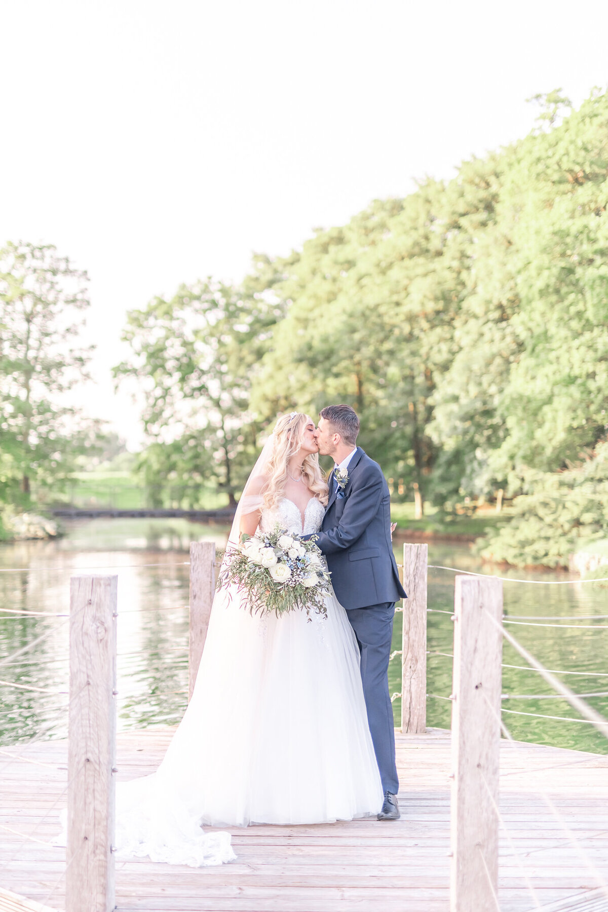 Bride and groom kissing on the lake at Merrydale Manor Cheshire Wedding