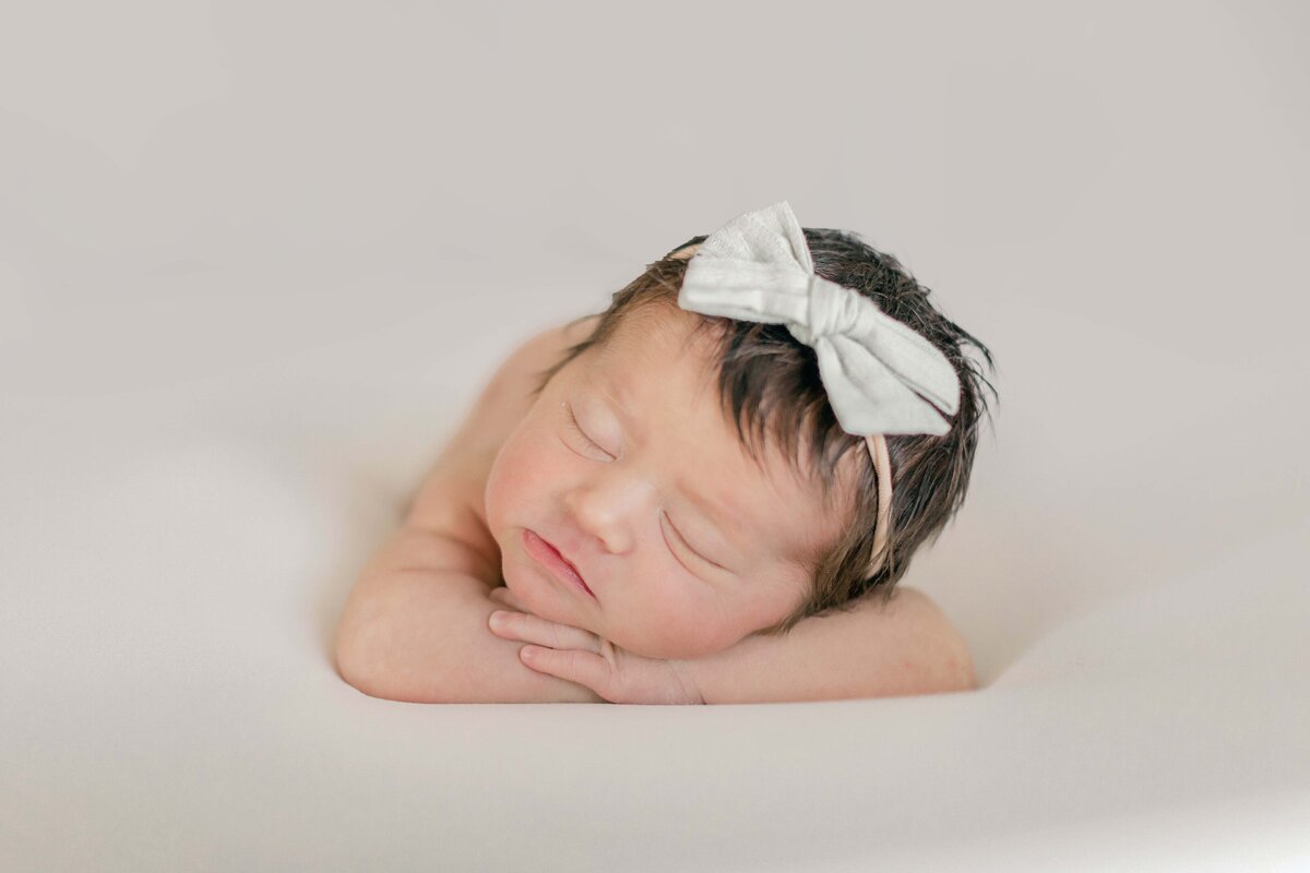 baby posed on a light and airy backdrop during their in-home Cincinnati newborn session