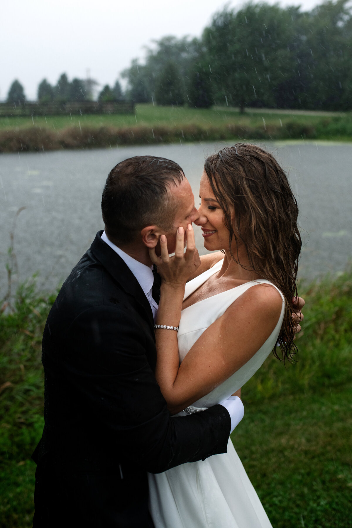 newlyweds getting rained on their wedding day and not afraid to get wet