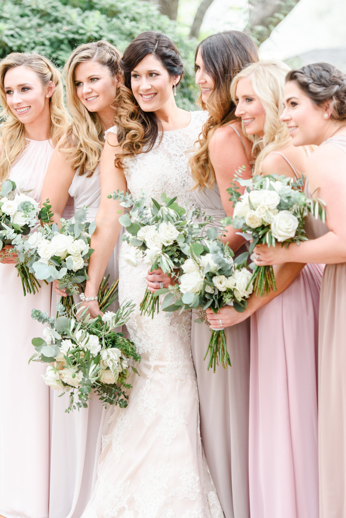 bride and her bridesmaids smiling with flowers