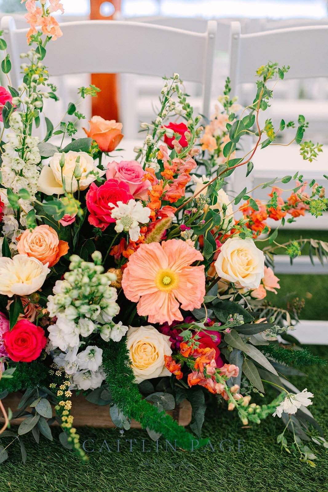 Bright, gorgeous poppies and summertime florals designed at the wedding ceremony entryway