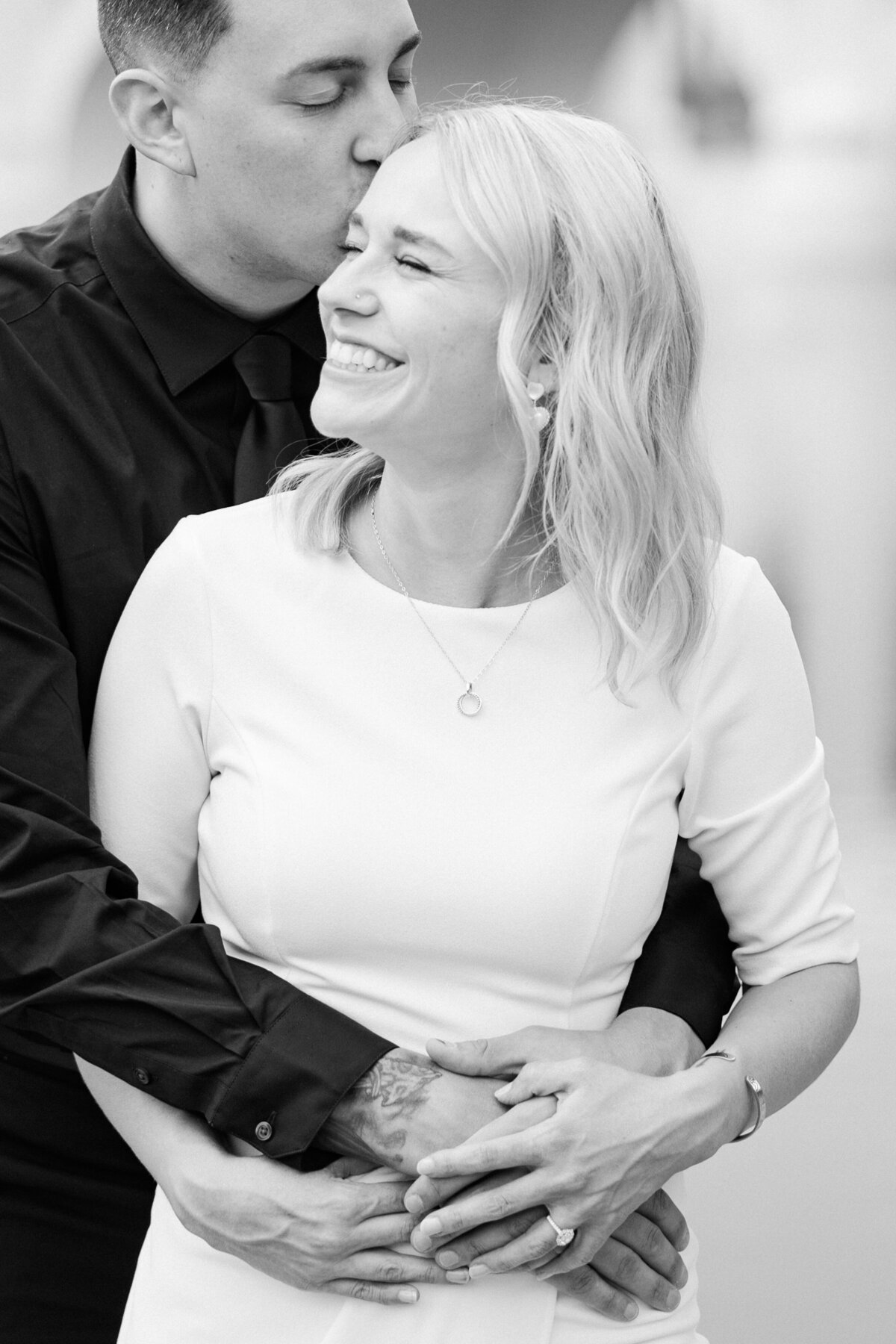 A romantic moment as the engaged couple kisses and snuggles together during their engagement session at St. Anthony Main in Minneapolis captured by minnesota wedding photographer.