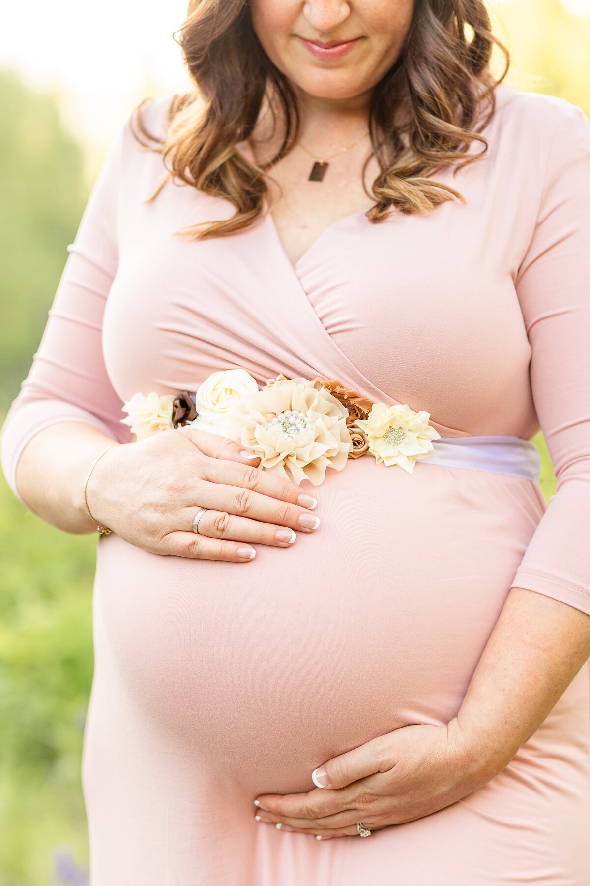 a close up of a pregnant woman holding her baby bump