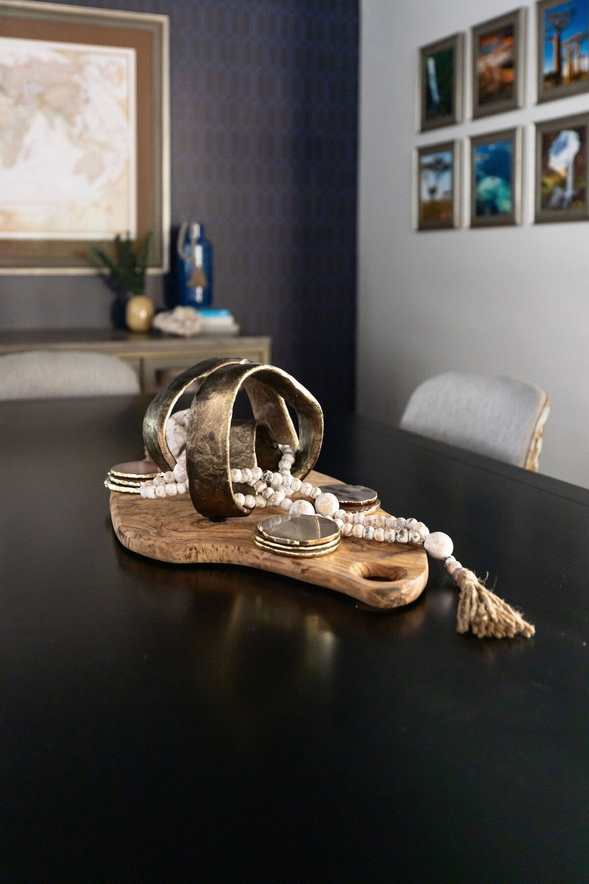 Organic wood tray with sculptural metallic centerpiece and decorative beads styled on a dining table in Phoenix, AZ