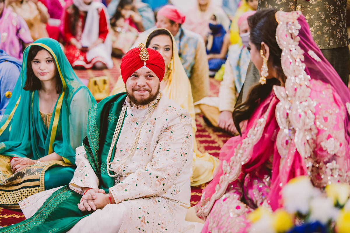 A sikh groom has a teary first look with the bride at the anand karaj wedding ceremony