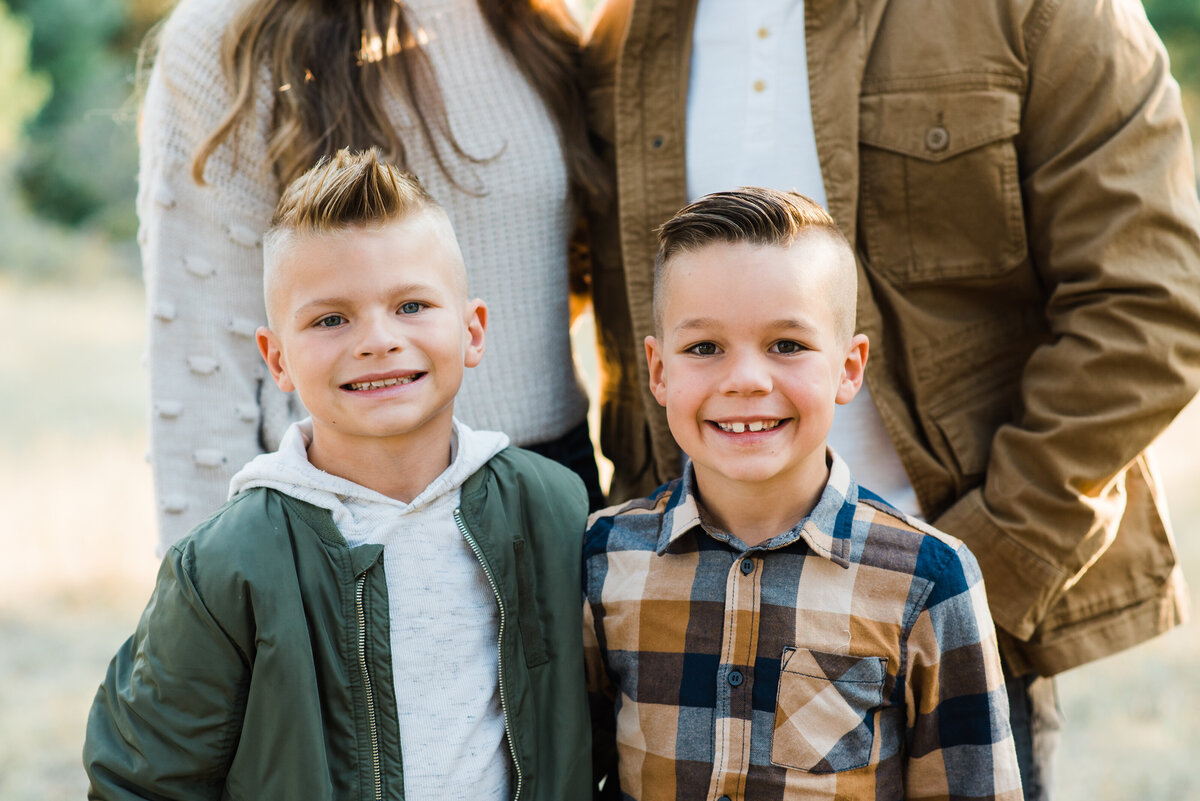 fall family photos with two brothers posing together and smiling captured by denver family photographers