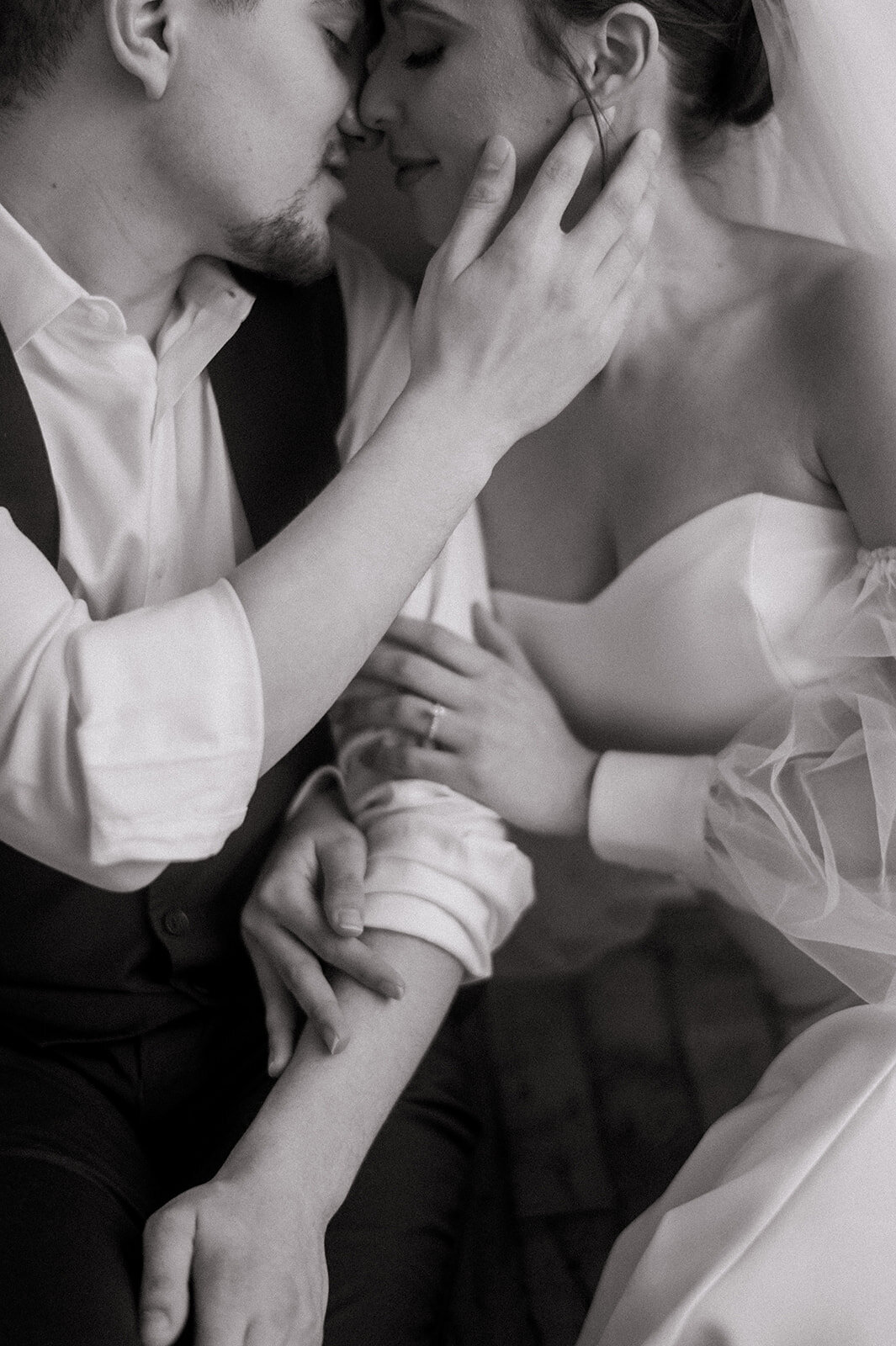 groom touches brides face as they share embrace photo by cait fletcher photography