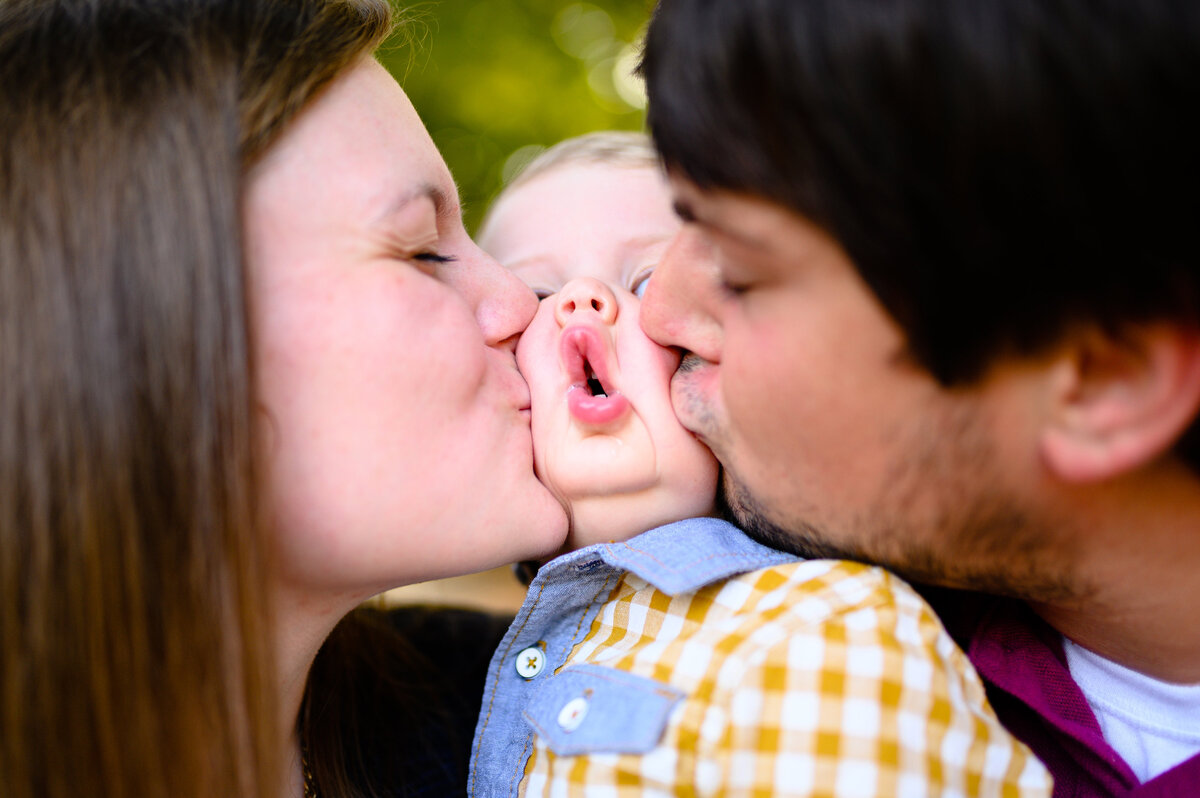 family-portraoit-kissing-baby-cheeks