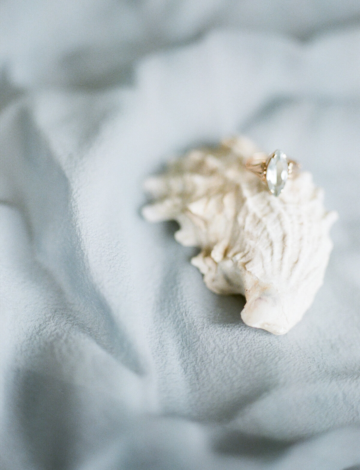 yellow gold marquise cut aquamarine engagement ring on seashell, blue silk, Mediterranean wedding film photographer