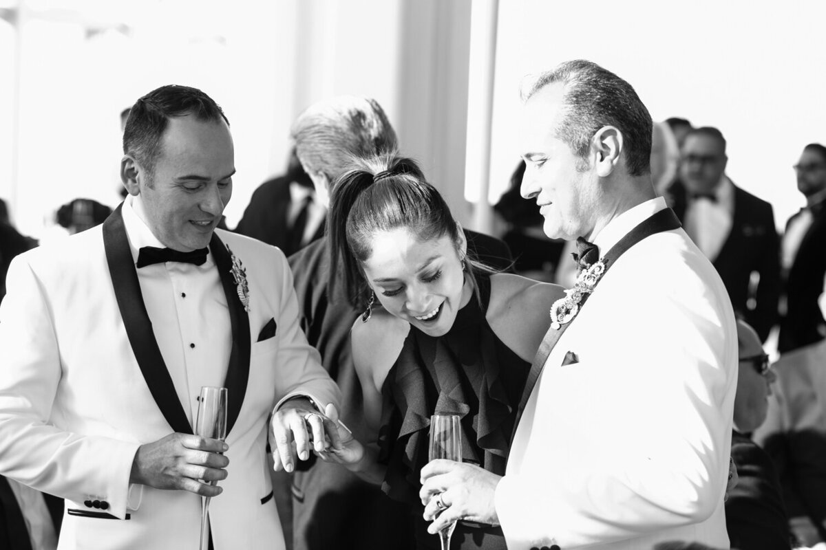 A wedding guests smiling and looking at groom's wedding rings