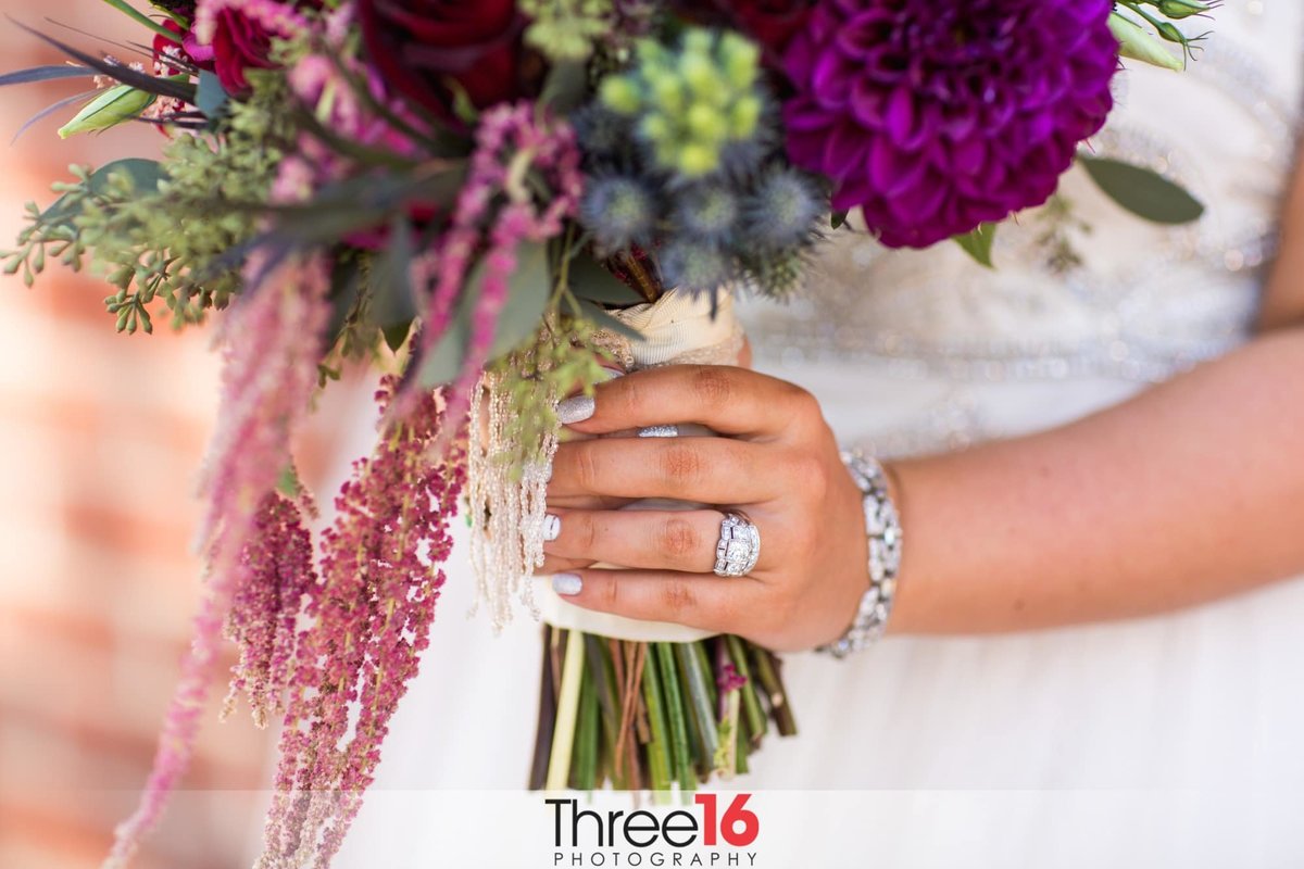 Bride holds the stems of her bouquet