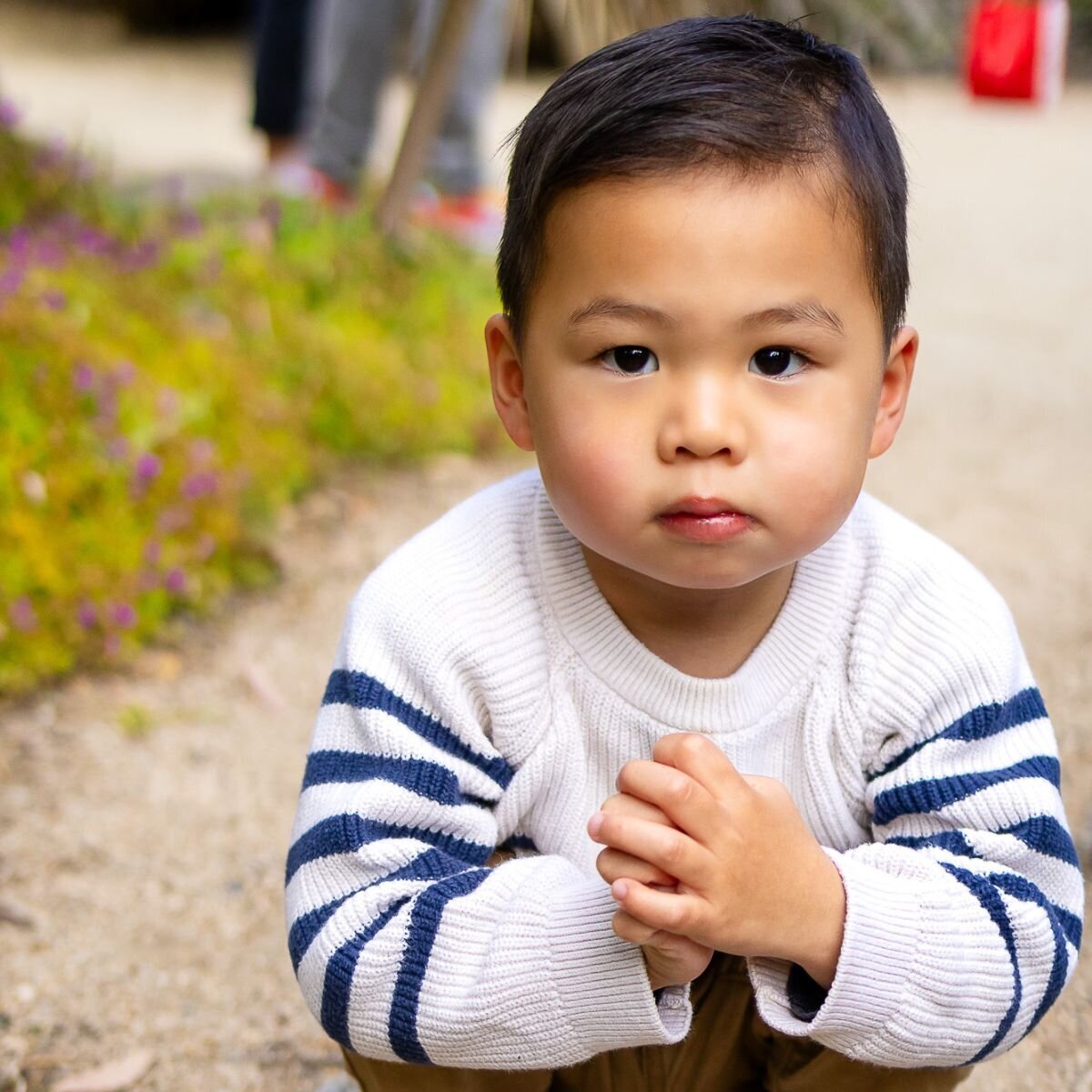 Young boy crouching outdoors during Bay Area school photography lifestyle portrait – Ellobelle Photography