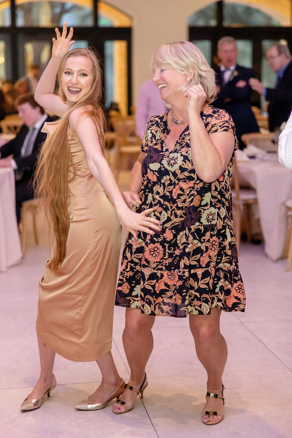 Fort Worth Wedding Photographer captures two women guests dancing and laughing at reception