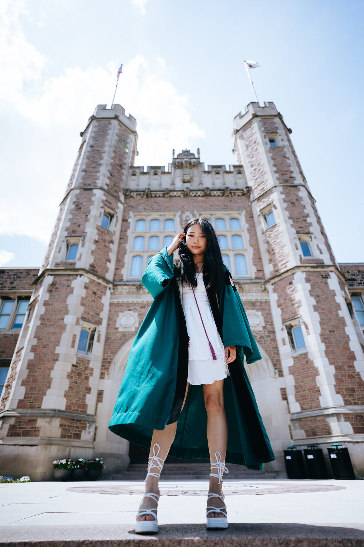 washu grad standing in front of brookings hall wearing regalia