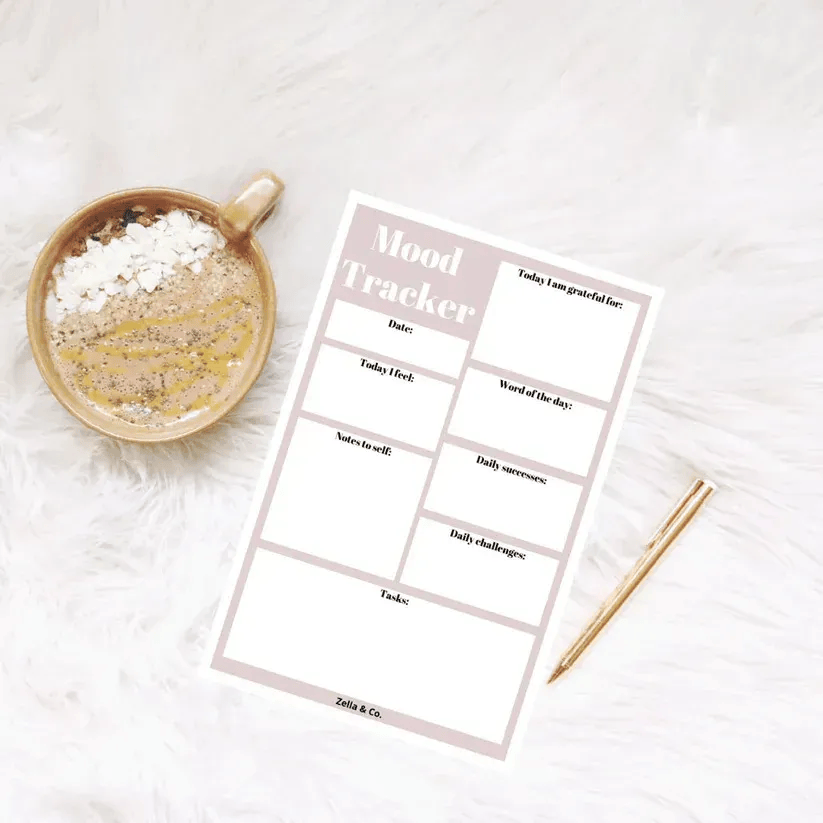 Peak Interactive Wellness mood tracker worksheet with pen and coffee, available in Denver and Greenwood Village to support mental health journaling and self-reflection.
