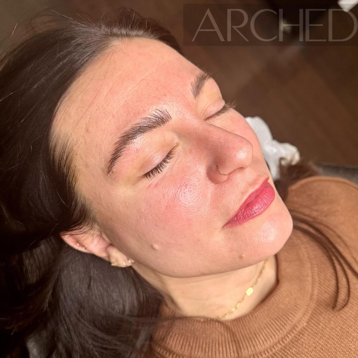 Female enhanced eyebrows that look naturally fluffy, through nicroblading services at ARCHED Coastal in Gulf Shores, Alabama.
