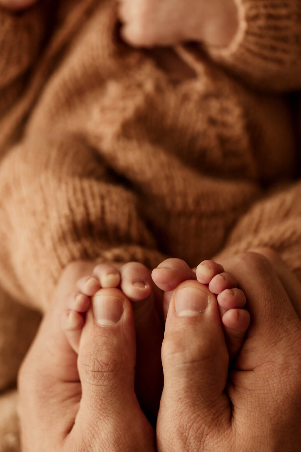 Father holds his son's newborn feet.