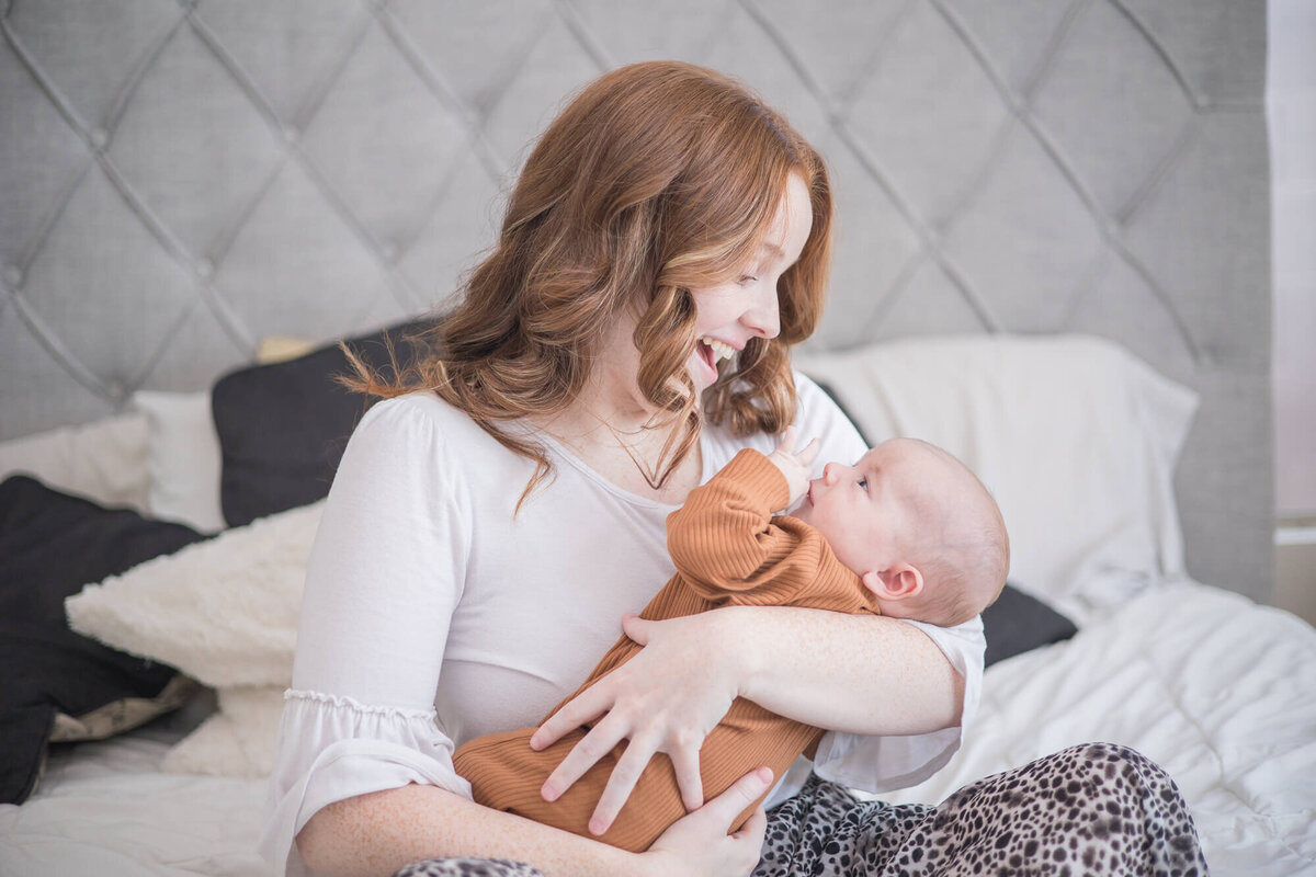 Redheaded mom playfiully talking to  infant son during their las vegas newborn photography session with Jessica Bowles\