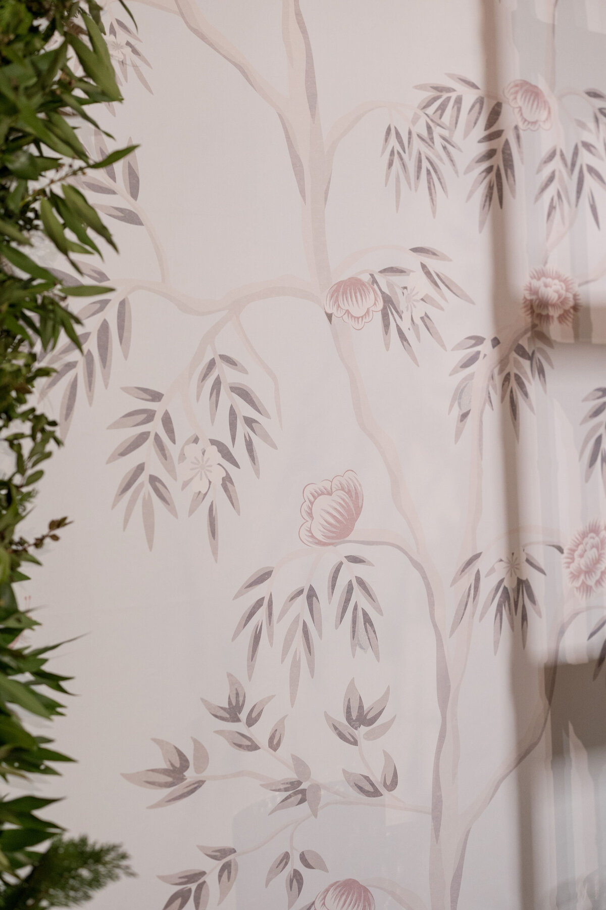 Close-up of a floral printed fabric, showcasing intricate designs of branches and blossoms in soft hues.