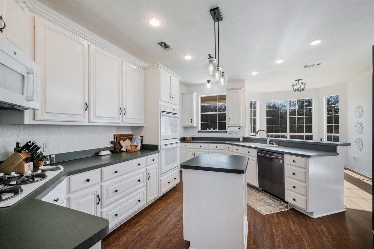 White kitchen with island and bar home for sale in Collinsville, Tx