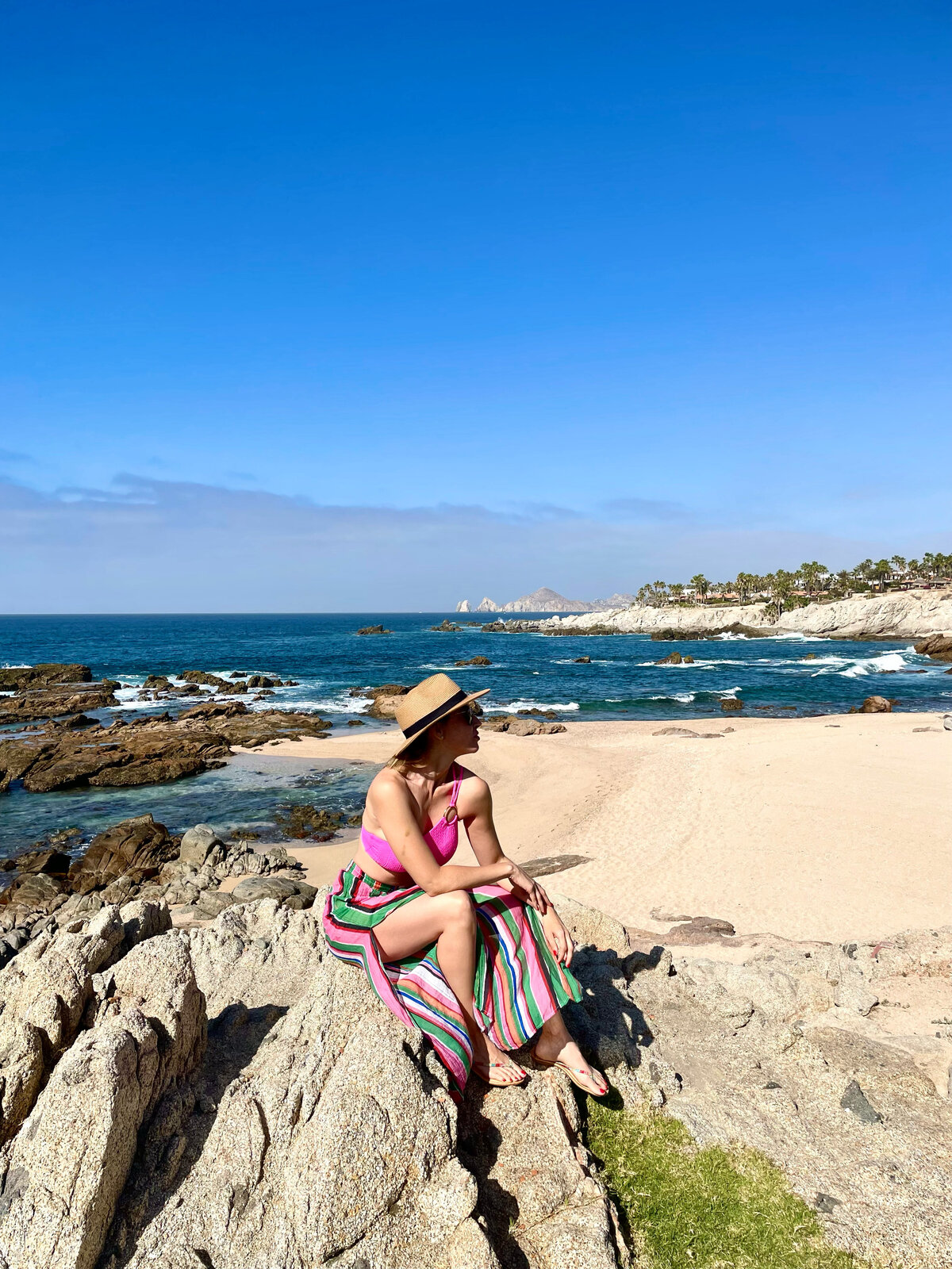 Woman posing a rock  with the beach on the background