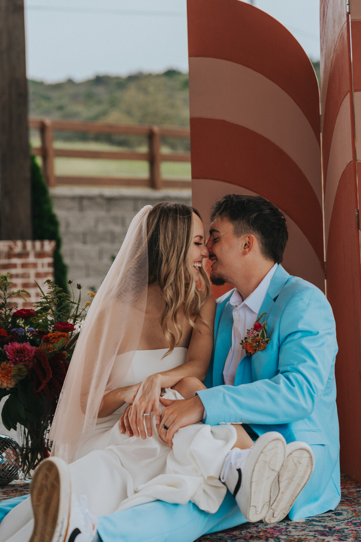 Man in a bright blue suit prepares to kiss his wife