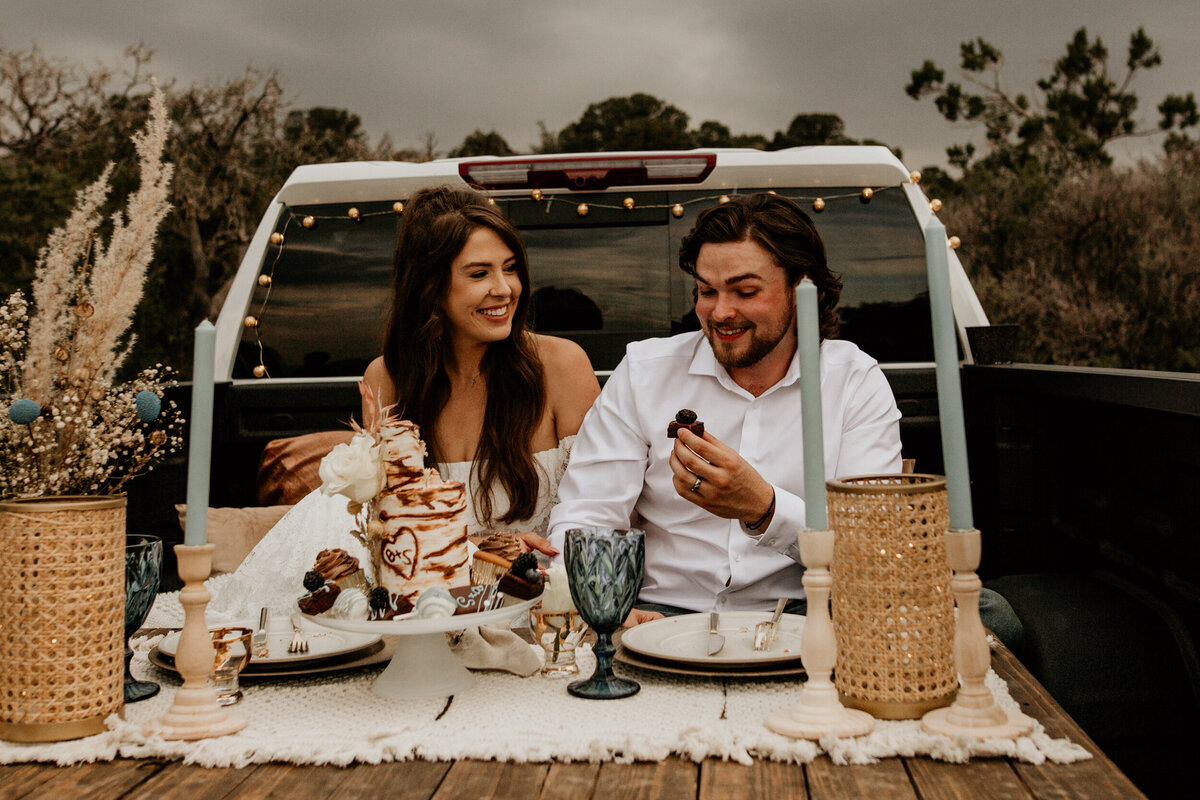 newlyweds  feeding each other cake in their truck bed in New Mexico