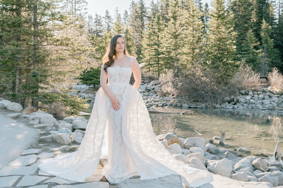 Closeup bridal photo in floral lace dress against pine trees