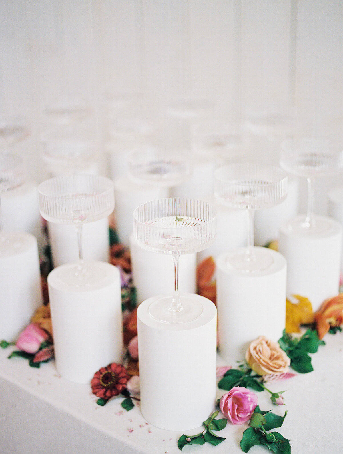 Display of champagne flutes for guests on white pedestals