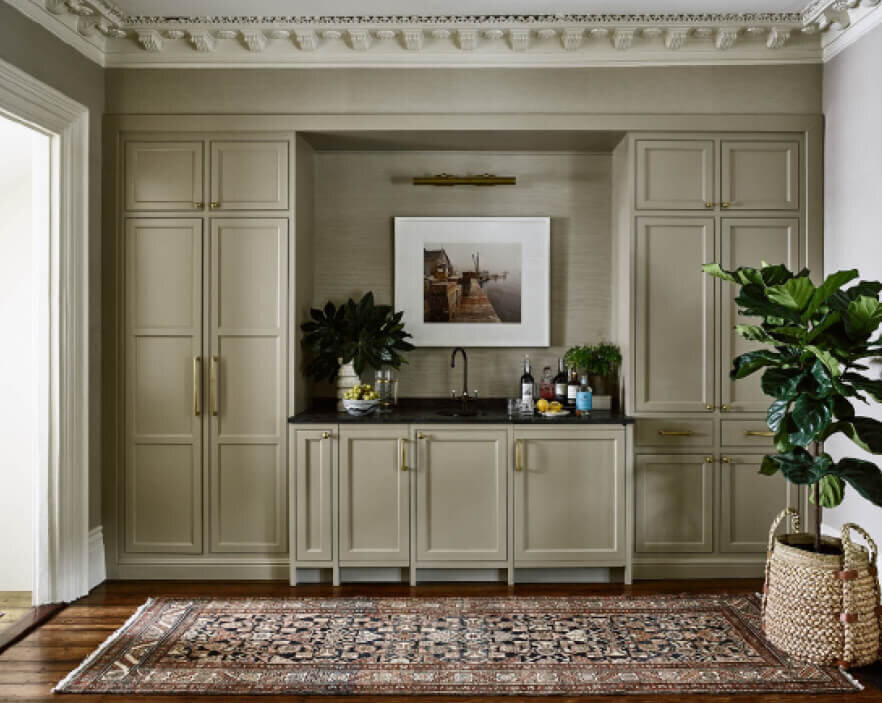 Top Boston Interior Designer designed custom cabinets with a sink, ice maker, beverage refrigerator, art lamp, and a vintage runner in a brownstone interior design project.
