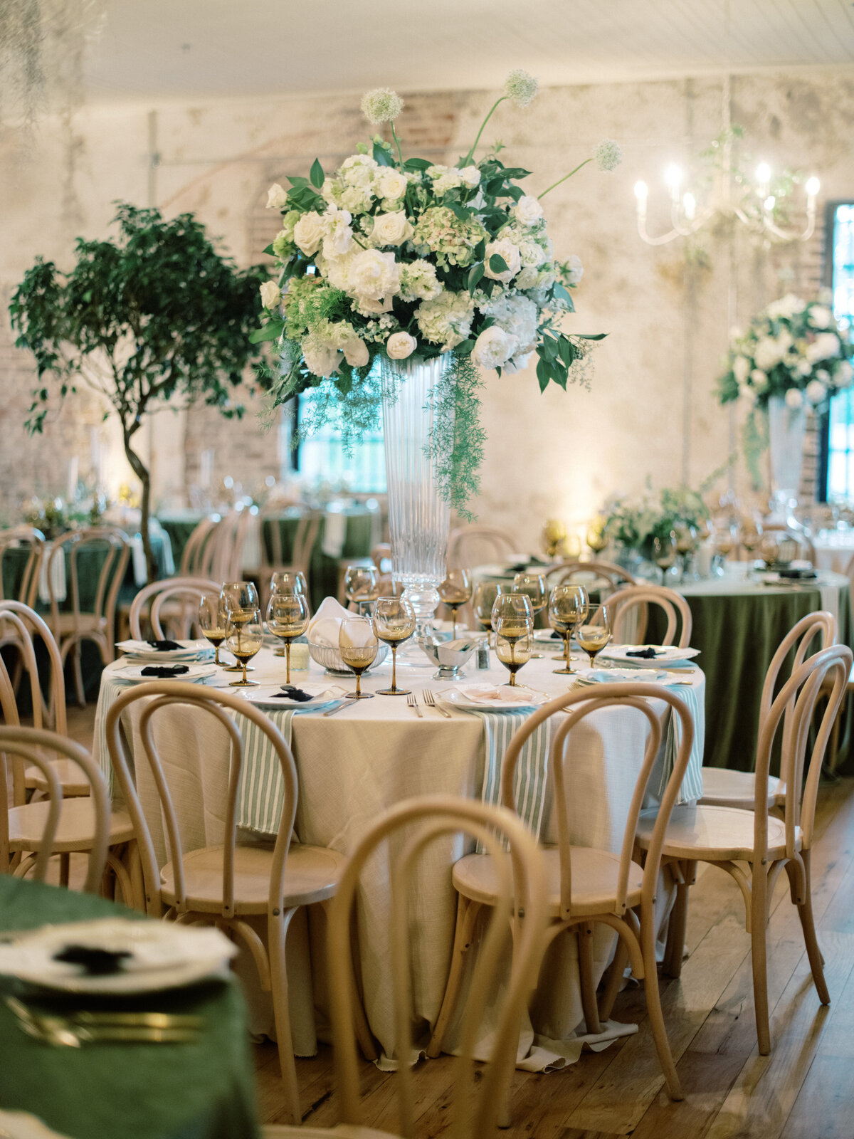 An elegant wedding table setting featuring towering floral arrangements, refined tableware, and a stylish layout that creates a stunning visual impact for the reception.