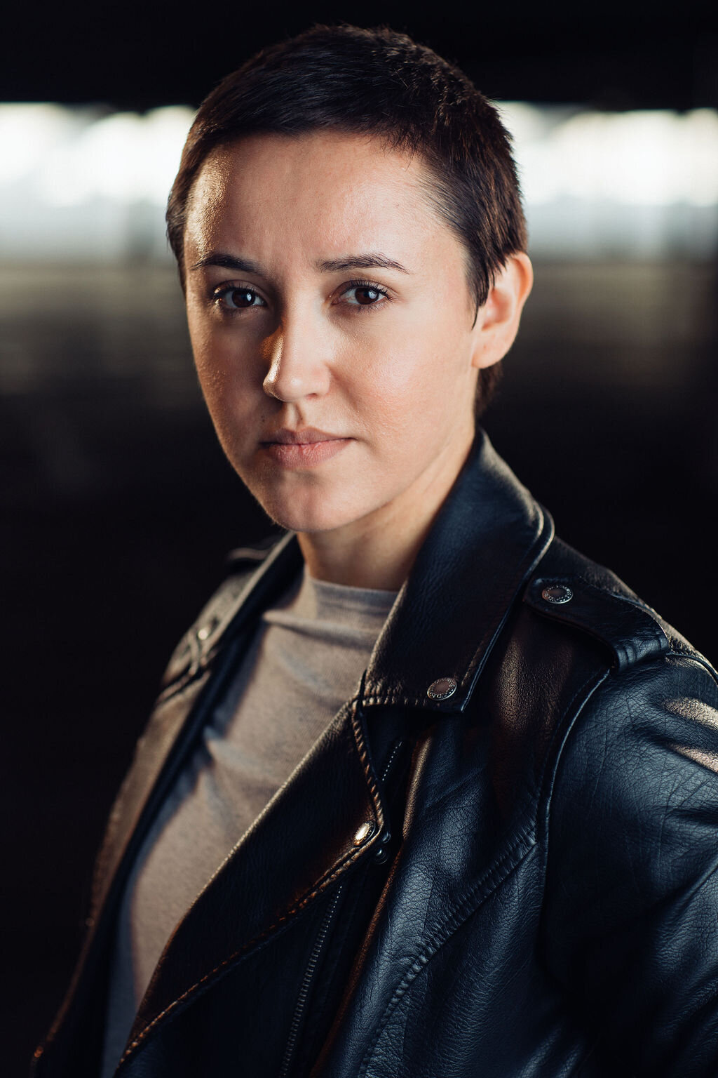 Headshot Photograph Of Young Woman In Outer Black Leather Jacket And Inner Light Gray Shirt Los Angeles