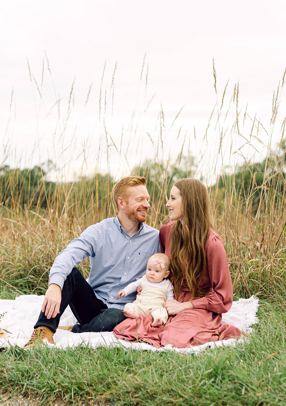 Couple and baby on picnic blanket