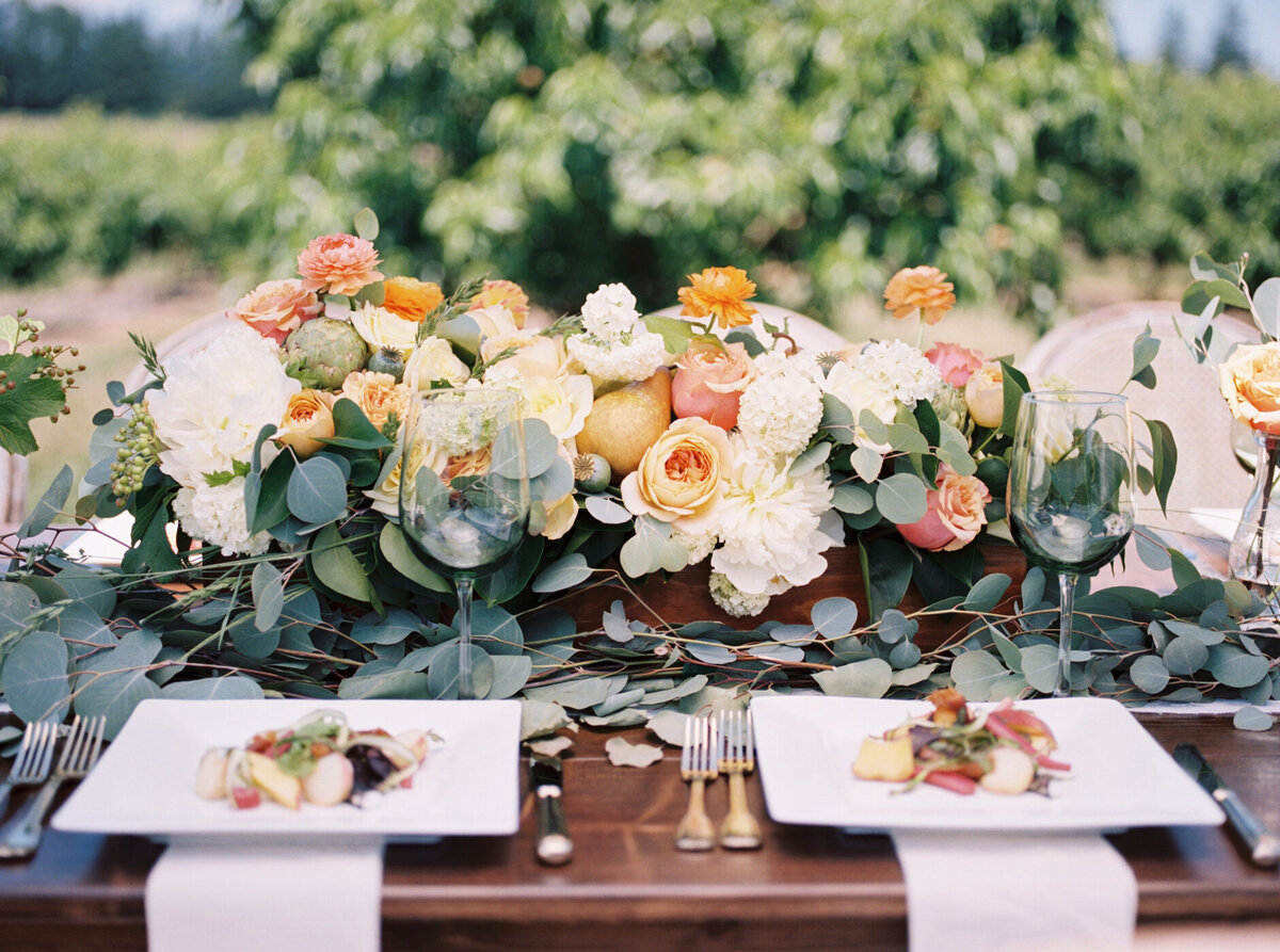 trellis florals center pieces on farmhouse tables at maysara winery with gold flatware