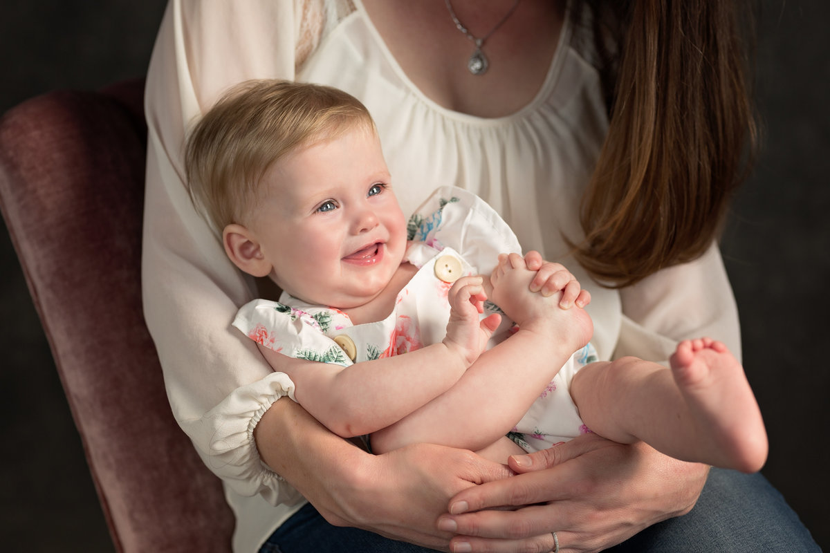 baby-girl-holding-foot-smiling-moms-lap-5F0A4342
