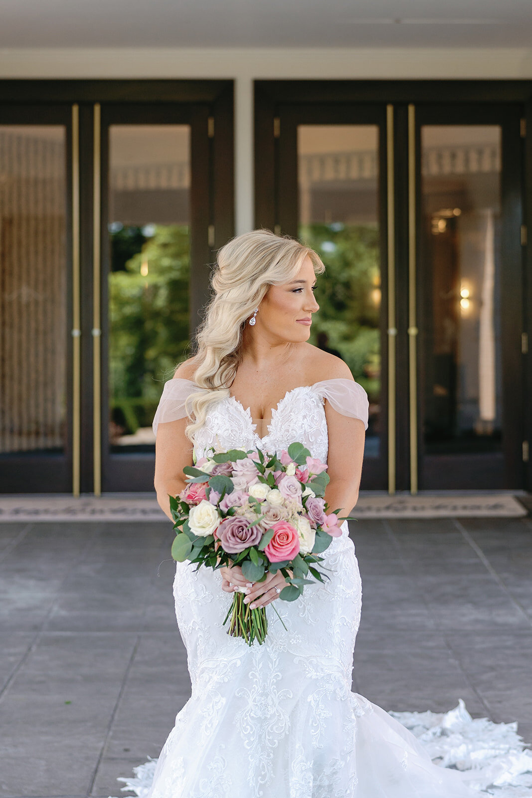 Bride in a lace wedding gown with off the shoulder sleeves