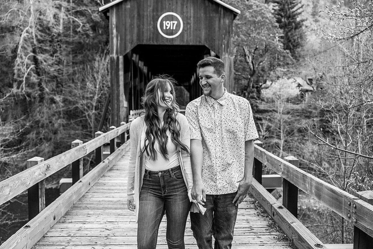 Cute couple laughing on a covered bridge