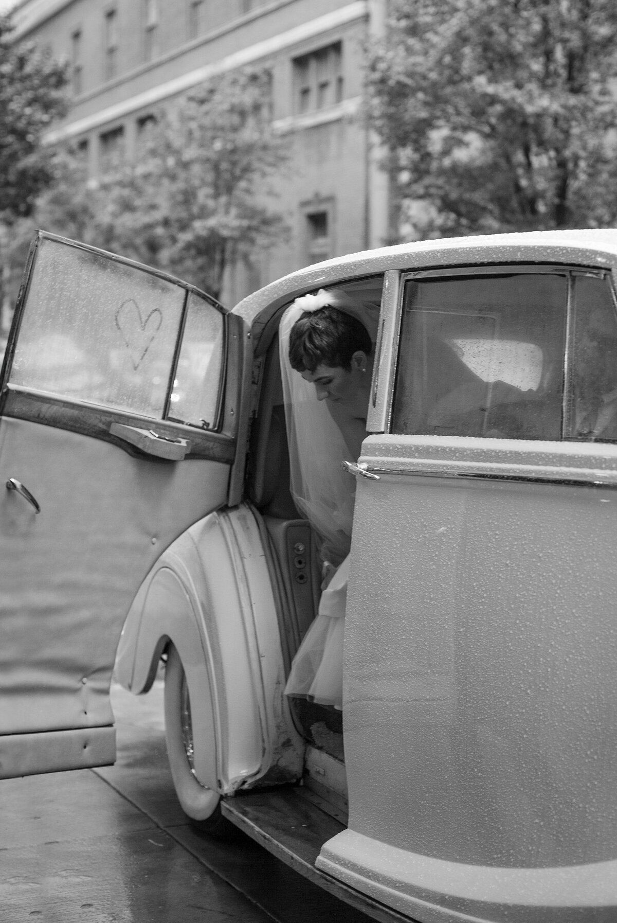 Bride gets out of classic car after arriving to her wedding ceremony in Boston.