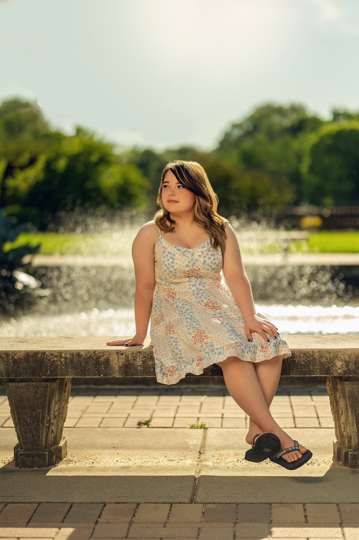A girl from Pewaukee High School takes a break on a bench in Eagle's Paradise Springs during her senior photo session.