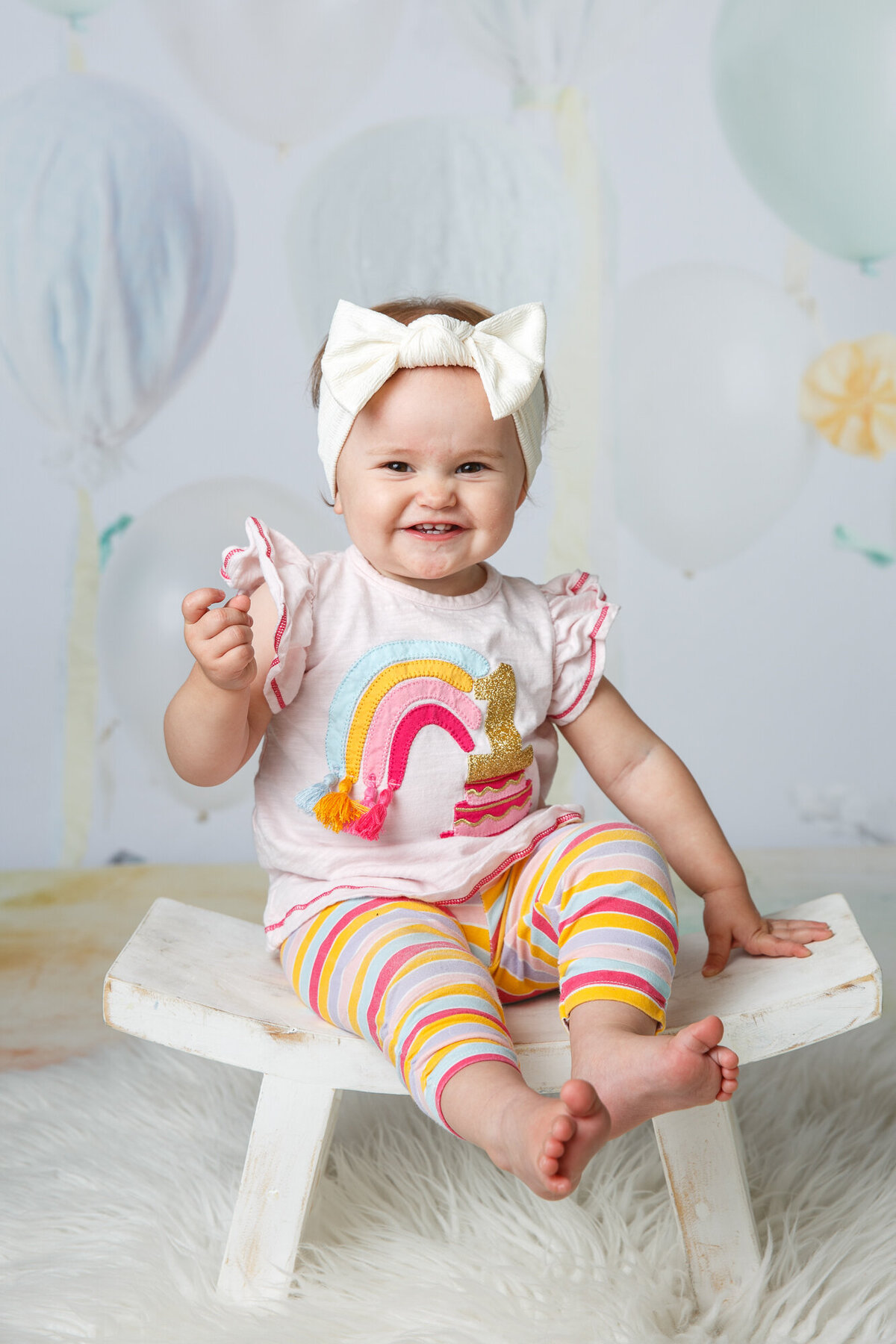 Cute toddler girl wearing a rainbow shirt and smiling