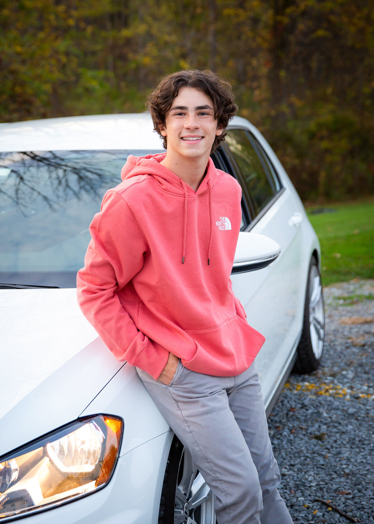 Senior photo of a guy with his car