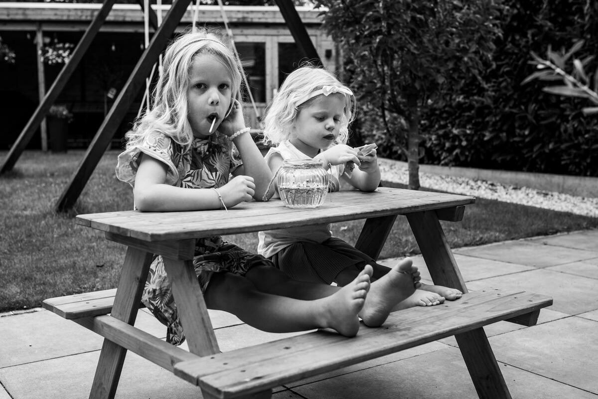meisjes eten een lolly aan tuintafel